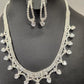 Detailed view of Silver hued three piece jewelry set