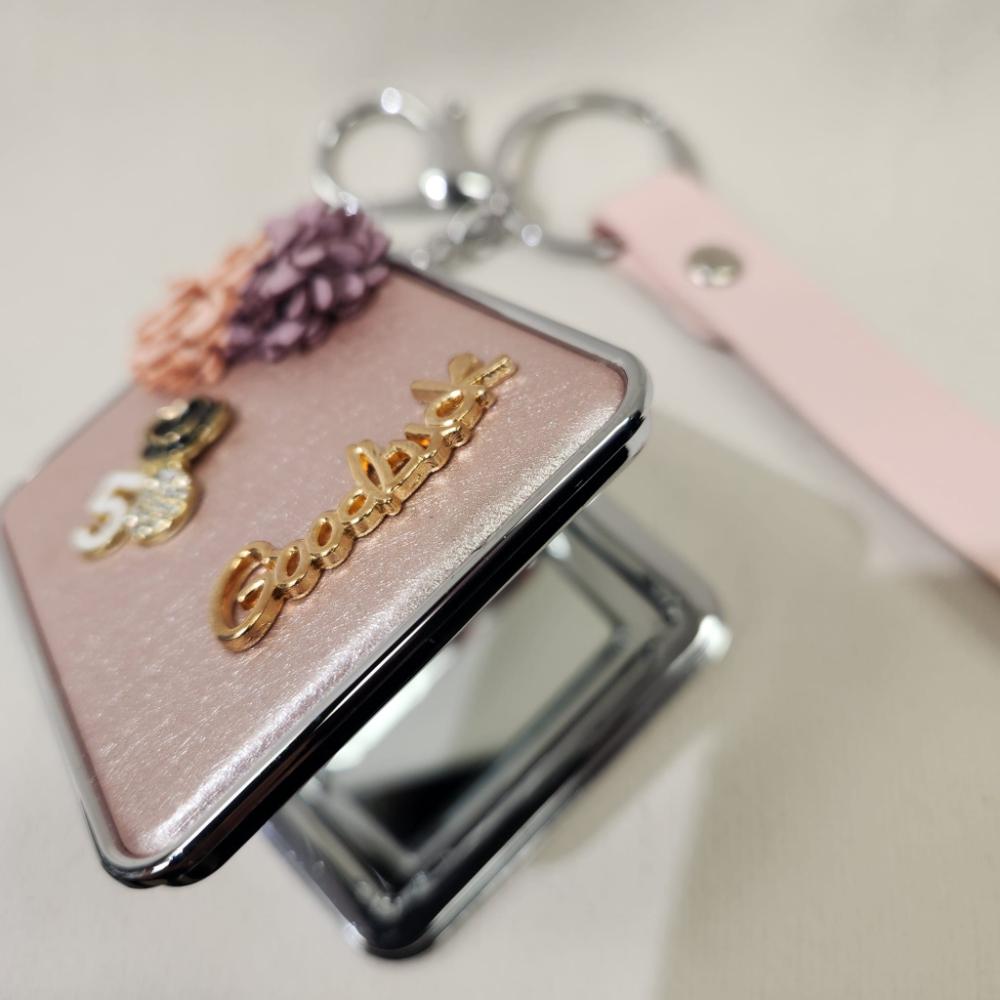 Detailed view of Mirror purse charm in pearly pink finish