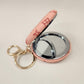 Peach Pocket mirror with engraved floral pattern and a keyring when opened