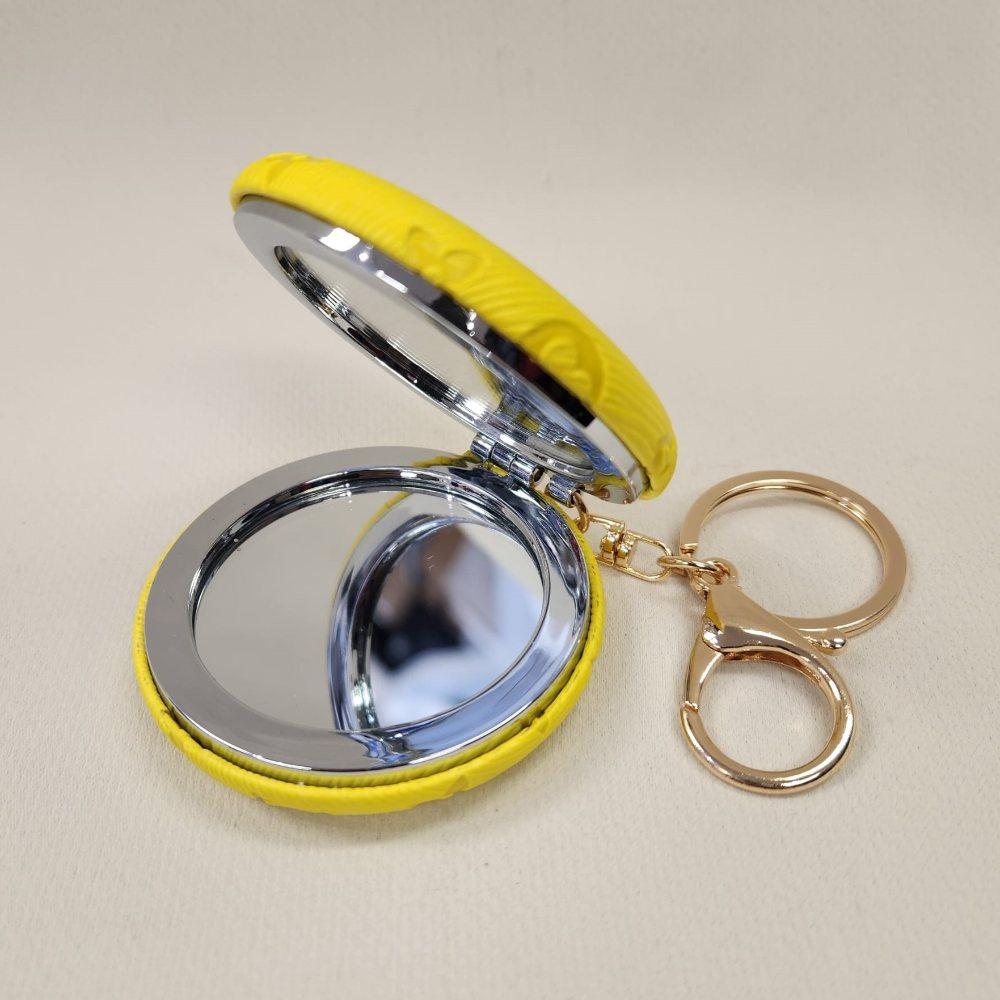 Yellow Pocket mirror with engraved floral pattern and a keyring when opened