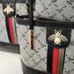 Detailed look at the gold bee insignia on handbag