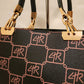 Gold color hardware on handbag with brown signature print