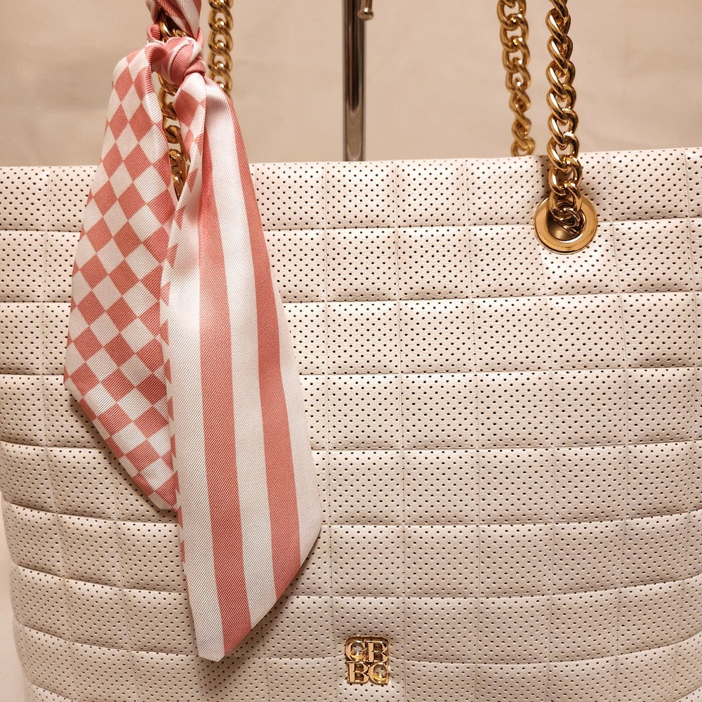 Perforated quilted exterior of off white handbag