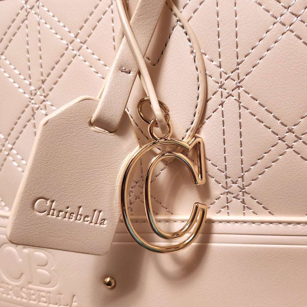 Detailed view of hardware on cream colored handbag