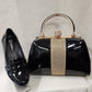 Black patent handbag displayed next to patent black shoe