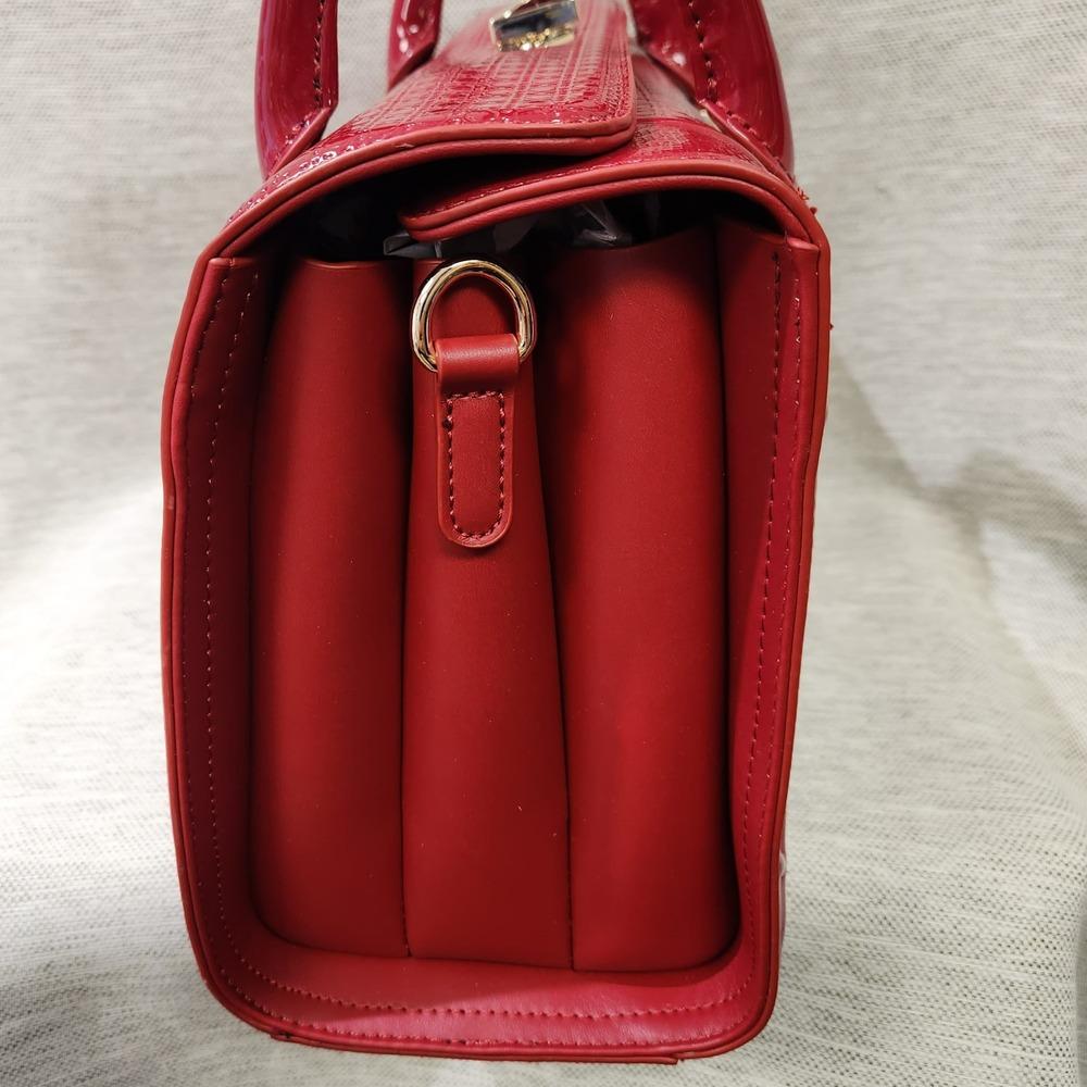 Side view of Red patent Fold-top handbag with matching wallet