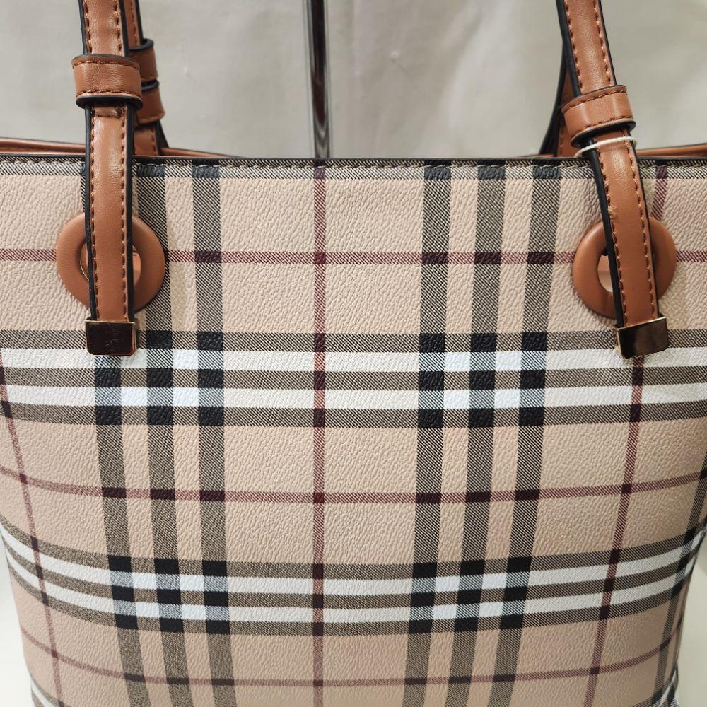 Detailed front view of plaid pattern handbag with tan handle