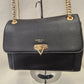 Detailed front view of Elegant black handbag with gold colored chain strap