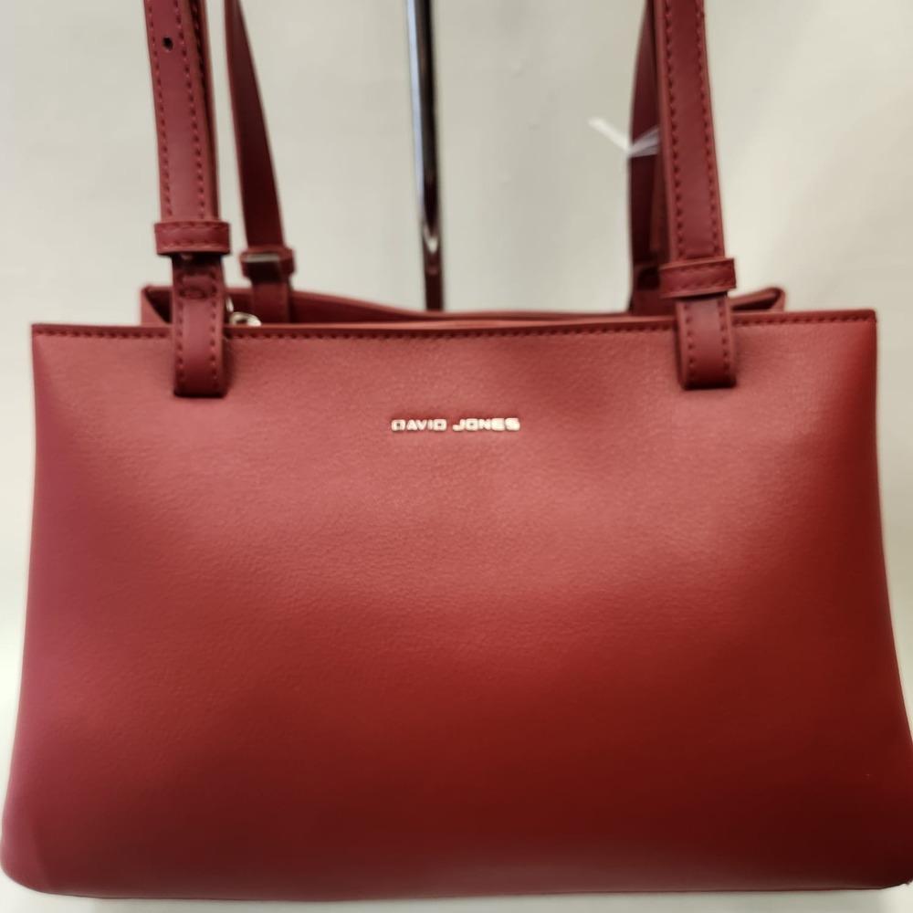 Detailed front view of Mid size burgundy colored handbag