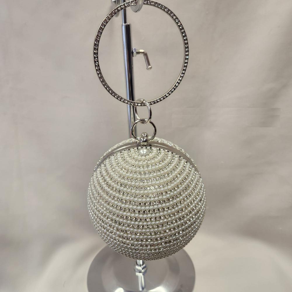 Round handle of globe shaped purse with pearls and stones