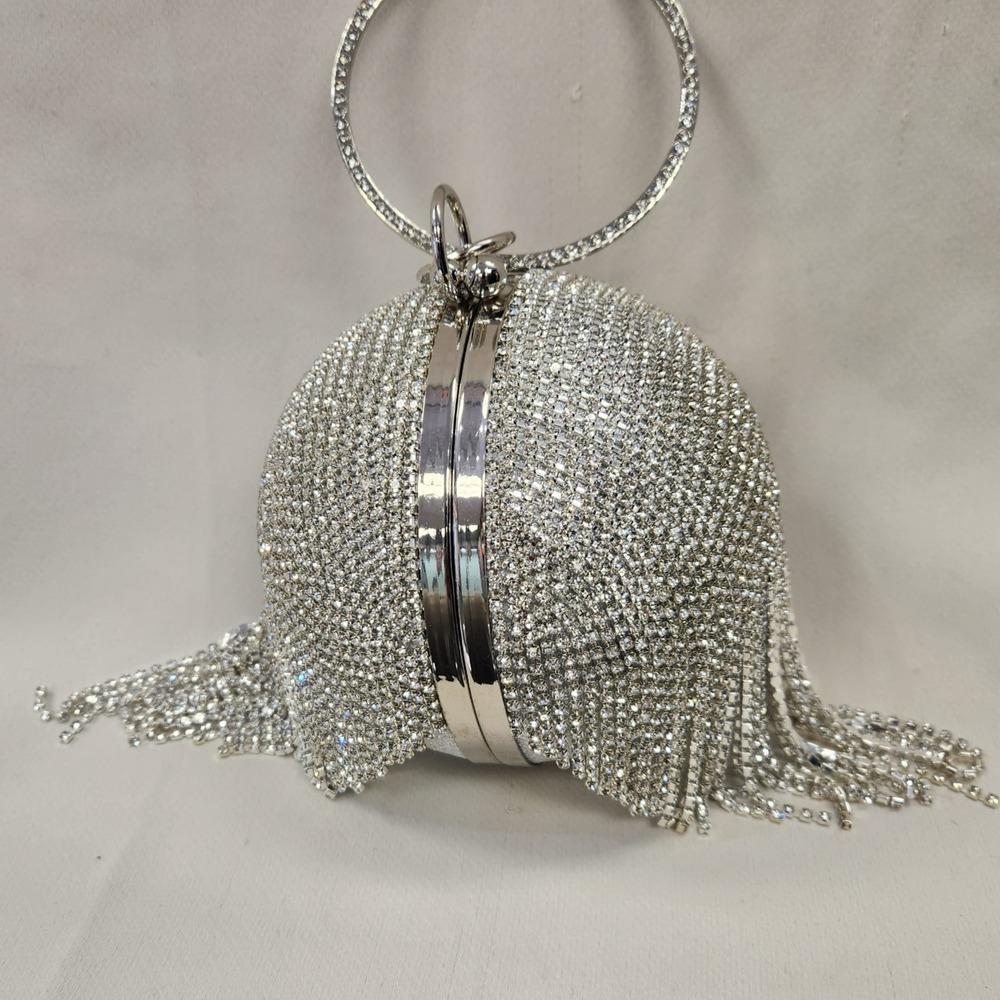 View of Silver globe shaped party purse with clear stone tassels 