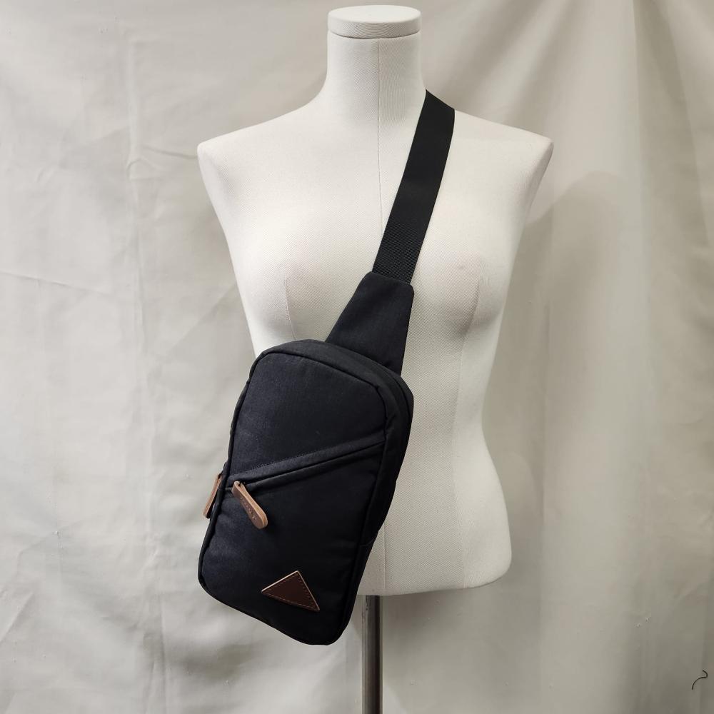 Multi pocket black side bag with tan colored details 
