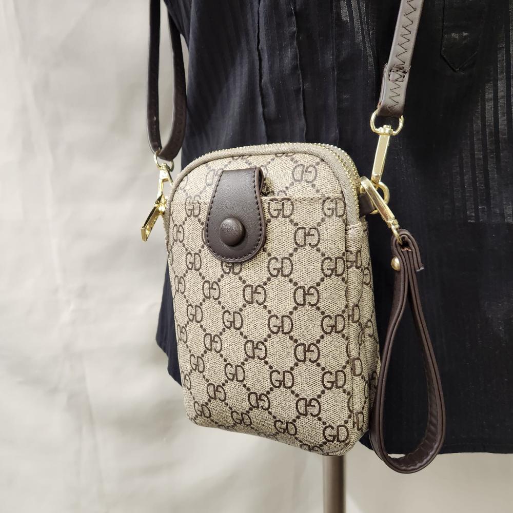 Detailed view of Signature print side bag in beige with brown print and strap