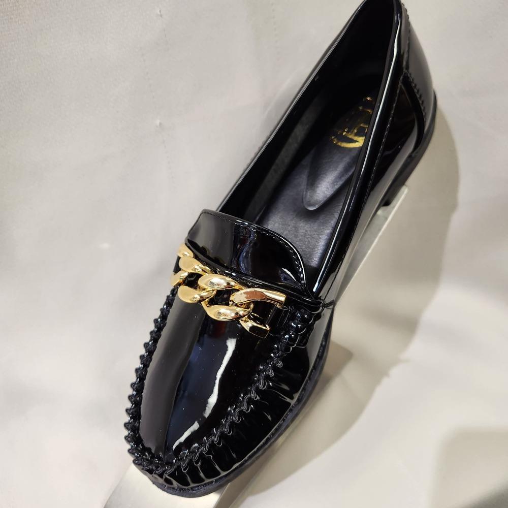 Front view of black patent flat shoes for women with gold buckle