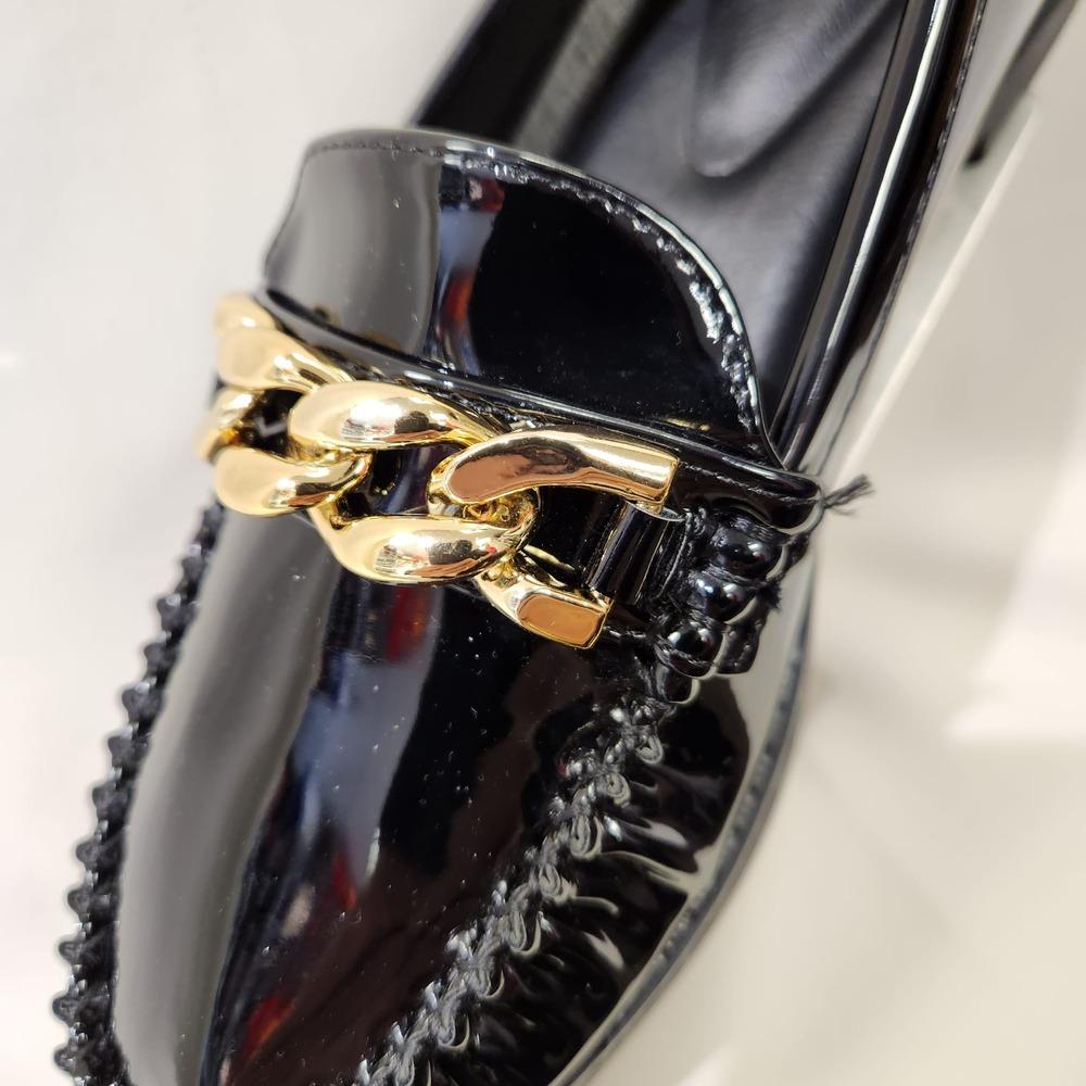 Gold link chain decorative detail on black patent flat shoes