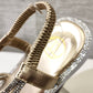 Detailed view of sling back design of gold stone studded strappy summer sandals