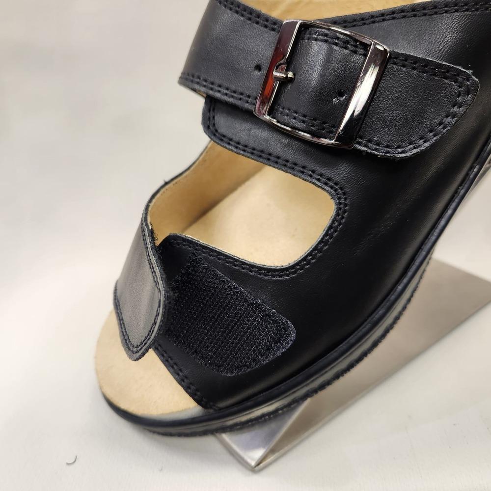 Velcro front closure of black slip on sandal