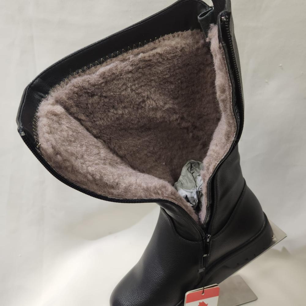 View of natural sheep wool lining of black winter boots