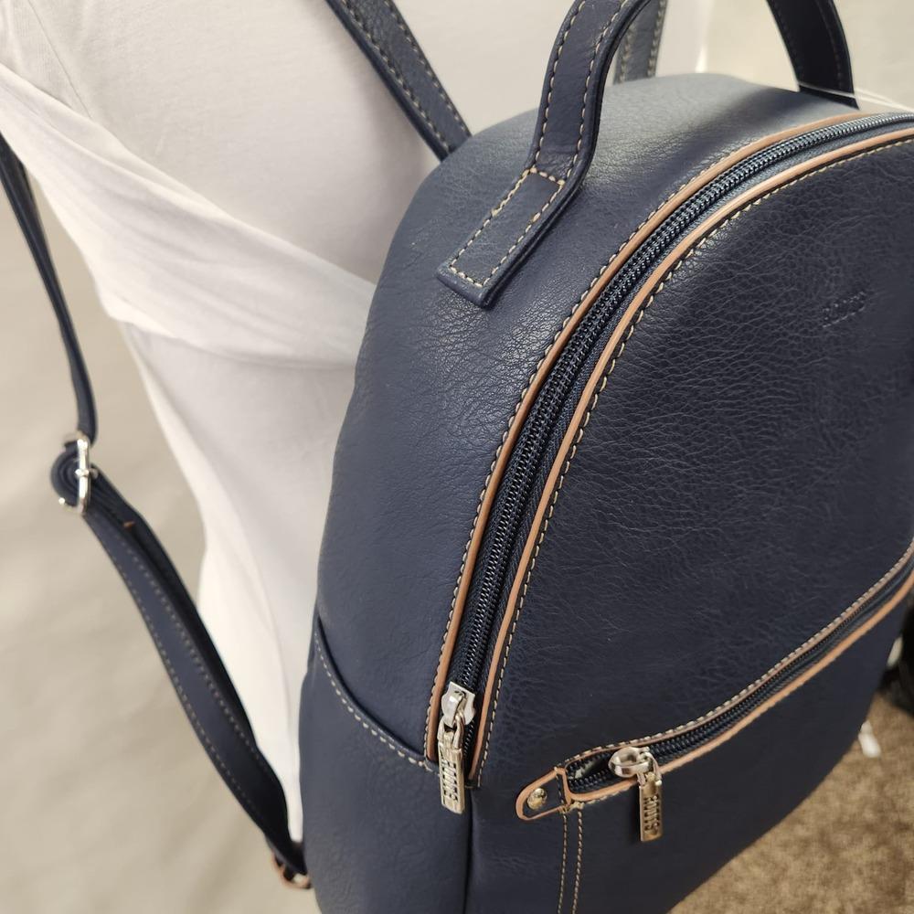 Detailed side view of Roots backpack in blue with tan trim
