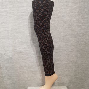 Full view of black leggings with tan colored signature print