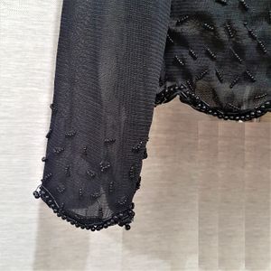Detailed view of sleeves for black fancy sequins top 