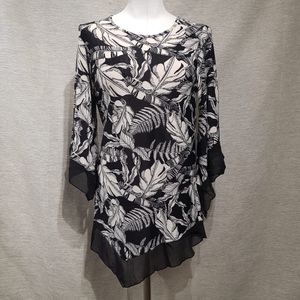 Full view of printed black and white top with asymmetric hemline 