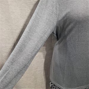 Side view of light grey top with fold over hemline