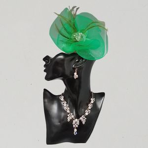 Green fascinator adorned with net yarn, pearls and feathers