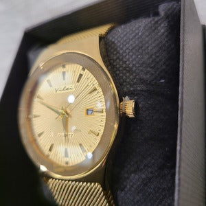 Side view of Gold round dial wristwatch with magnetic closure strap