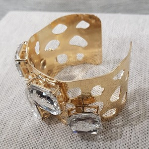 Detailed view of Gold color cuff bracelet with large square stones