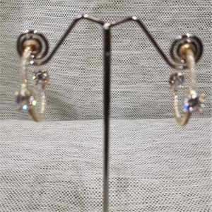 Front view of open hoop gold earrings with stones