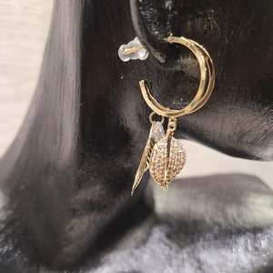 Side view of gold frame hoop earrings with dangling leaf detail