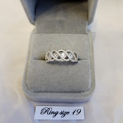Intertwined ring band with round and baguette shaped shopes