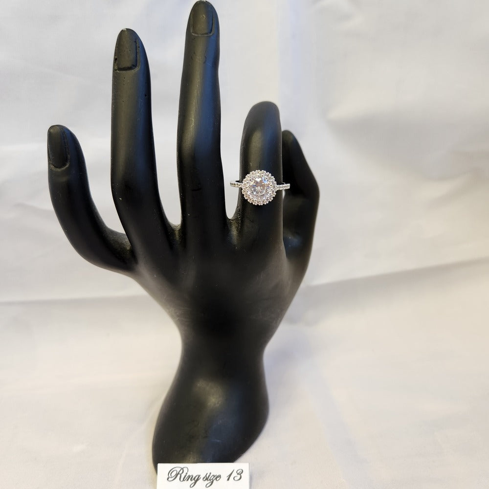 Halo shaped ring with studded band displayed on a mannequin stand