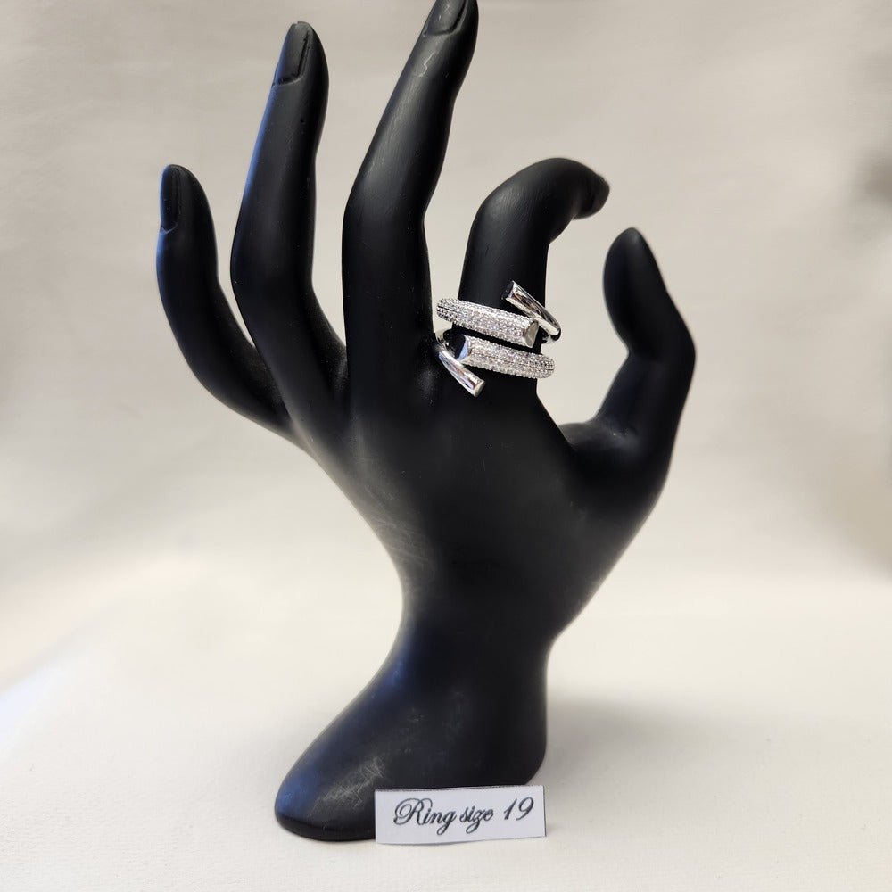 Modern bold stone studded silver color ring displayed on a  mannequin stand