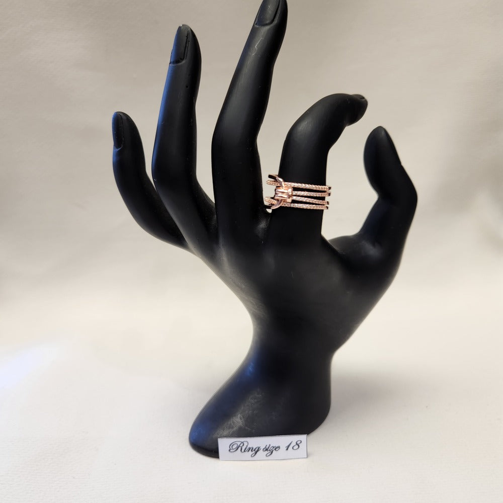 Multiple strand modern rose gold colored ring on stand