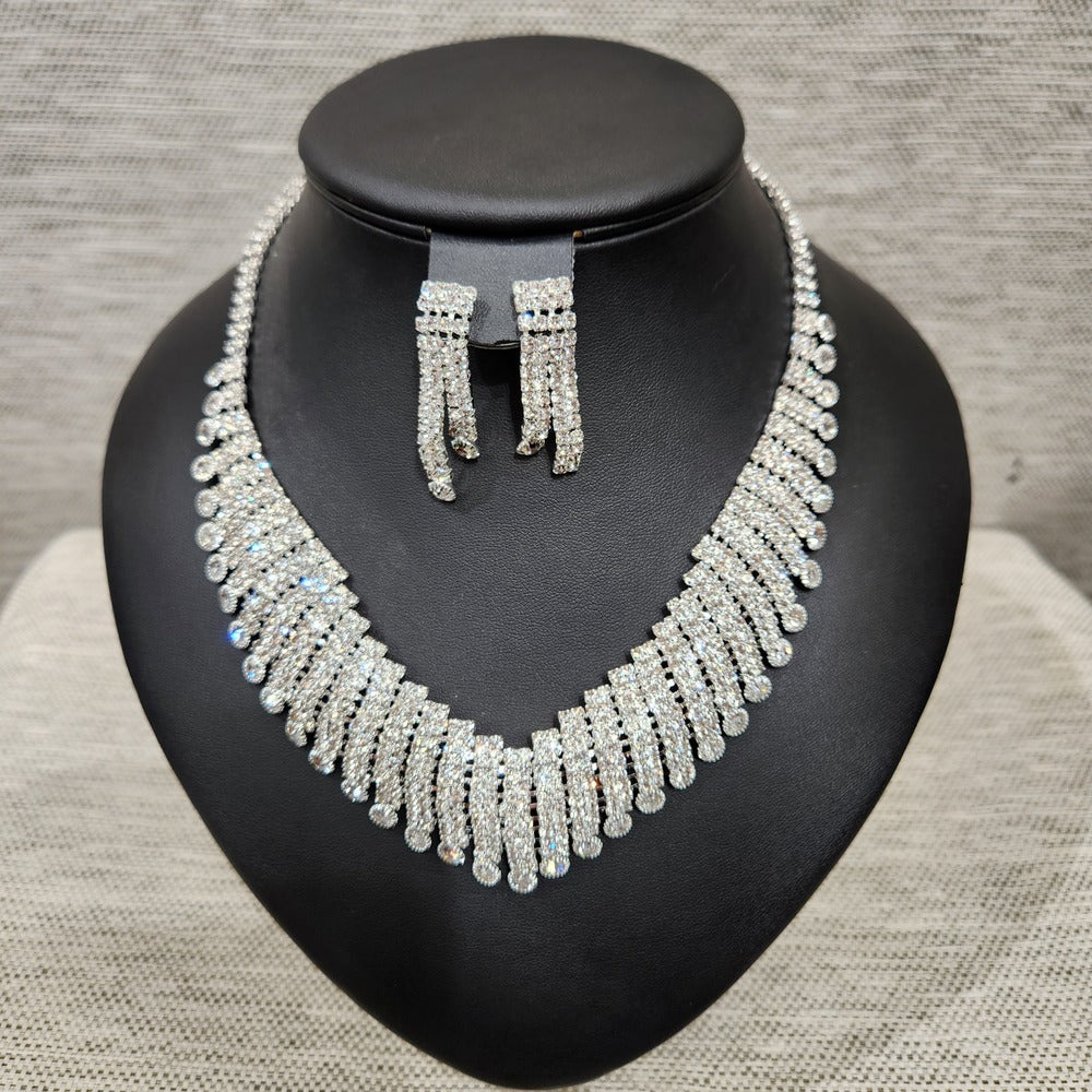 Full view of Silver color three piece jewelry set adorned with round clear stones