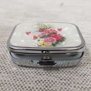 Small metallic pill box with floral pattern 