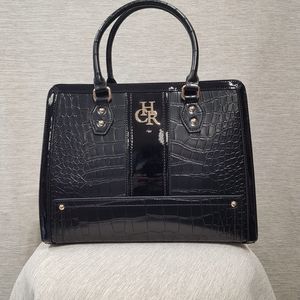 Front view of black patent handbag in croc. skin texture