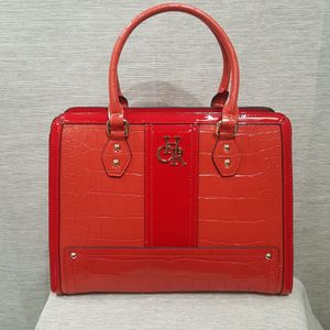 Elegant coral red patent handbag in croc. skin texture