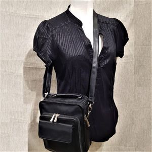 Full view of black multi-pocket side bag with top handle