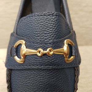 Detailed view of buckle of blue loafer for women