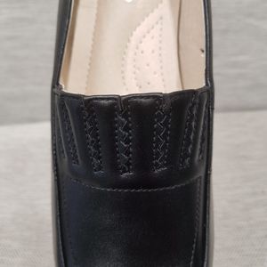 Detailed front view of black pumps with padded sole
