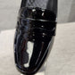 Front detailed view of black patent pumps 